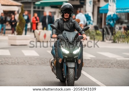 A modern motorcyclist drives on a motorcycle on the road in the city. Selective focus. High quality photo Royalty-Free Stock Photo #2058343109