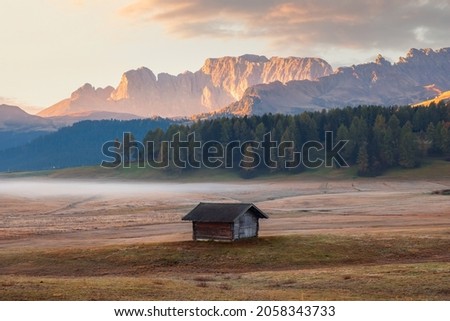Alpe di Siusi (Seiser Alm) alpine meadow with beautiful sunrise in the background with the Sassolungo and Langkofel mountains visible near the town of Ortisei in the province of South Tyrol in Italy