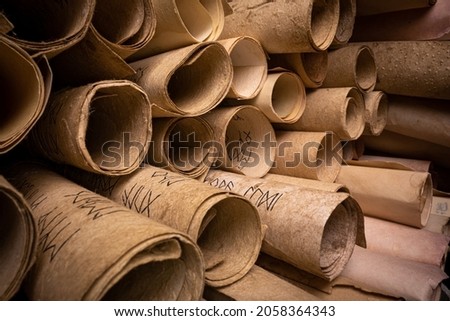Ancient scrolls stacked on pile. Old and damaged scroll library.  Royalty-Free Stock Photo #2058364343