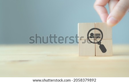 Buyer persona and target customer concept. Buyer or customer psychology profile or characteristics. Marketing analysis for business plan. Hand holds wood cubes with person data, magnifying glass. 