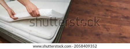 Mattress Topper Being Laid On Top Of The Bed Royalty-Free Stock Photo #2058409352