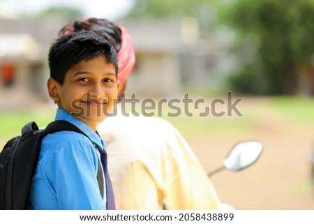 Young indian farmer dropping his child to school.