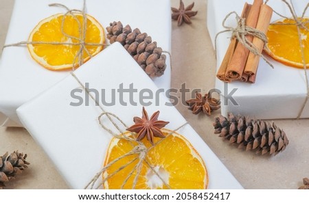 New Year composition. On beige craft paper, gift boxes, dry orange slices, pine cones, cinnamon, cloves. Cozy Christmas concept