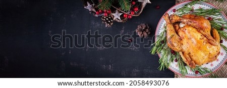 Baked  chicken or turkey. The Christmas table is served with turkey, decorated with bright tinsel. Fried chicken, table. Christmas dinner. Table setting. Top view, banner