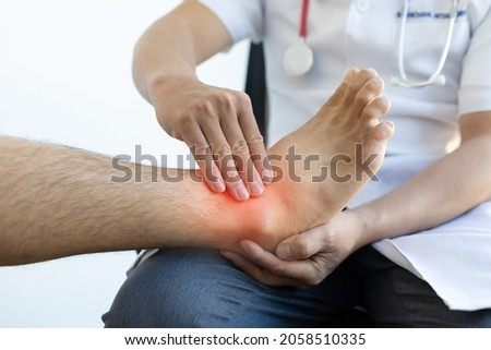 The doctor is diagnosing the pain in the patient's legs and ankles. Royalty-Free Stock Photo #2058510335