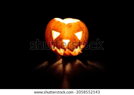 Jack's Lantern for Halloween. Scary Jack Lantern made from apple. Spooky face lantern on a black background