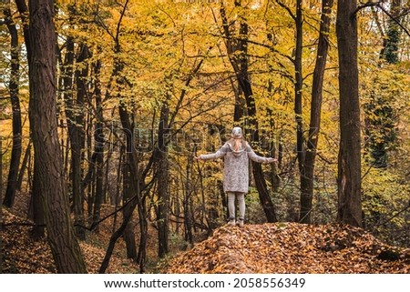 Woman enjoying fresh air and feeling positive energy in autumn forest. Getting away from it all. Digital detox in nature Royalty-Free Stock Photo #2058556349