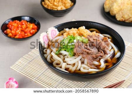 Japanese traditional noodle soup Niku Udon with kakedashi soup, fish stock soup and then topped with beef sukiyaki, tenkasu and sliced scallions. 