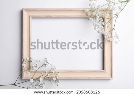 Wooden frame with beautiful gypsophila flowers on white background, top view. Space for text Royalty-Free Stock Photo #2058608126