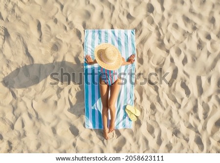 Woman sunbathing on beach towel at sandy coast, aerial view Royalty-Free Stock Photo #2058623111