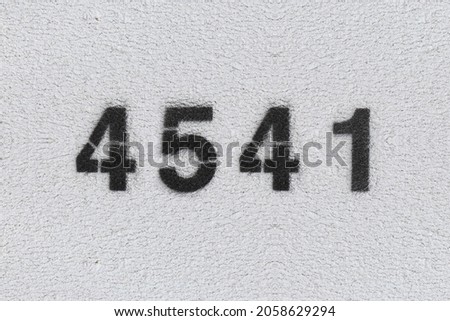 Black Number 4541 on the white wall. Spray paint. Number four thousand five hundred and forty one.