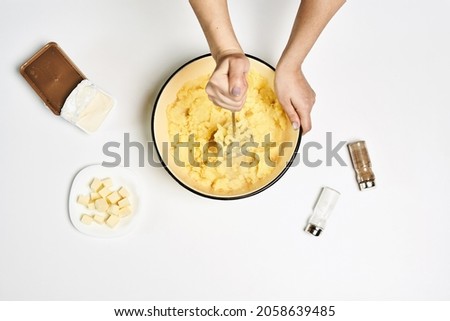 A female making a delicious puree with different ingredients on a white table Royalty-Free Stock Photo #2058639485