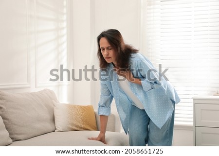 Mature woman suffering from breathing problem at home Royalty-Free Stock Photo #2058651725