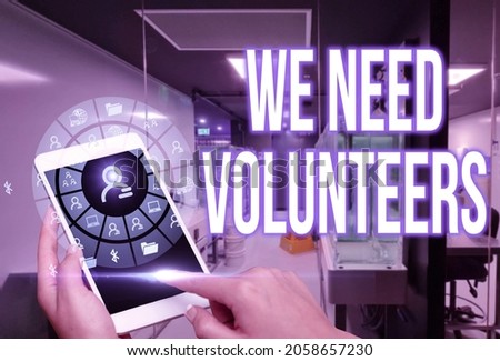 Text caption presenting We Need Volunteers. Conceptual photo someone who does work without being paid for it Woman Suit Writing On Screen Holding Tablet Showing Futuristic Technology.