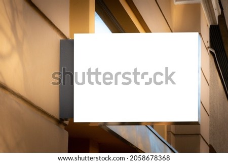 Mock up. Blank white rectangular shape signboard on the wall outdoors. Signage of shop, store, cafe, restaurant Royalty-Free Stock Photo #2058678368
