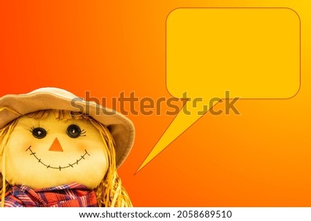 Autum Harvest background with little girl scarecrow doll with warm plaid scarf on gradient background with speech bubble - room for copy.