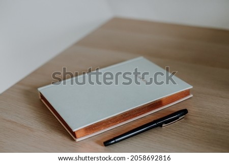 Notebook on the table with a pen on the side. Wooden table. Planner.