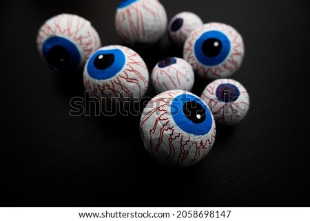 Funny halloween treat - Candy eyeballs on dark background. Copy space