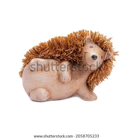 Hedgehog on a white background. The hedgehog lies on its side, a decorative figurine for the interior, a toy.