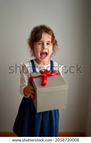 Happy laughing child girl with Christmas gift at home. Christmas surprise. Christmas holidays concept, New Years Eve