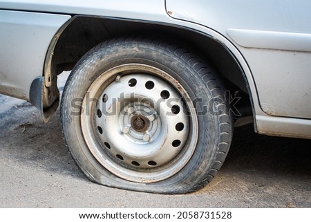 old car wheel. flat tire. an accident has occurred and assistance is required. dirty rubber tire Royalty-Free Stock Photo #2058731528