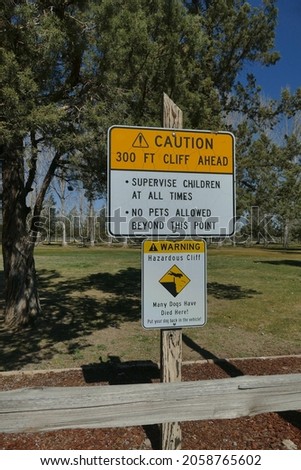 A vertical shot of a sign about doggie danger point in Peter Skene Ogden State Park Terrebonne, USA