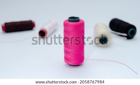 black, white, red, brown and cream threads with isolated white background 
