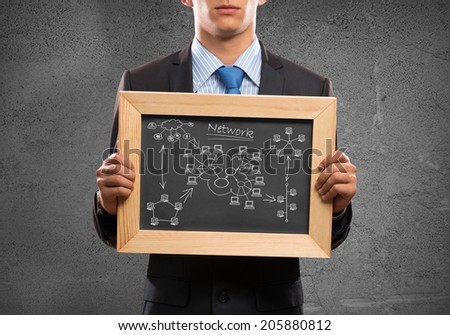 Young businessman holding chalkboard with business ideas