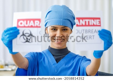 Portrait close up shot of happy beautiful doctor in blue hospital uniform tear quarantine outbreak alert paper sign apart when coronavirus pandemic end and normal life and business are back.