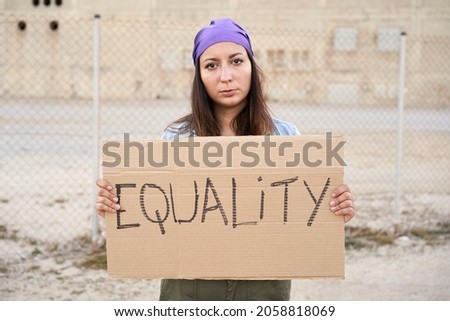 Feminist woman holding a placard saying Equality. Demonstration banners.