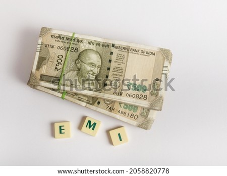 Indian rupee currency notes with EMI title. Heap of five hundred rupee notes on white background. Photo for Easy Monthly Installments. Royalty-Free Stock Photo #2058820778