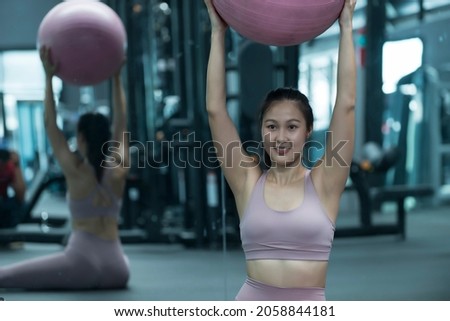 Young sporty  in a Pilates class at the gym. Young women doing sports training or workout with gymnastic ball in a gym.