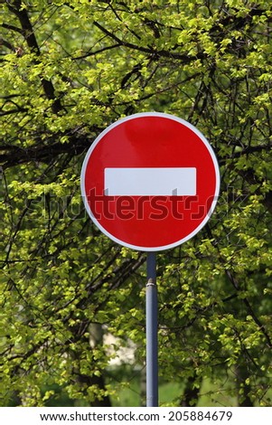 Forbidding road sign against tree foliage