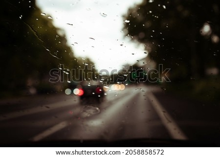 Photograph of the wet city after the rain, taken from inside a vehicle 