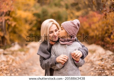 happy family mother and child daughter play and laugh at the autumn walk. Mother and child relations. Fashionable mother and daughter in a stylish look with the same jackets