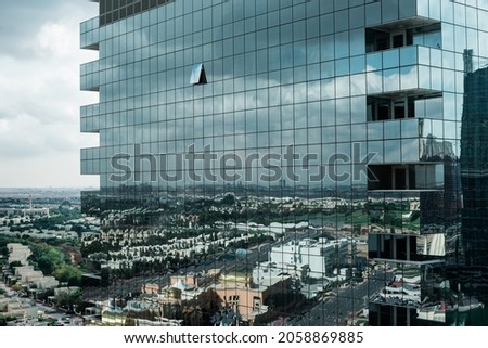 An abstract architectural photo of an urban landscape. Reflection of a massive residential community in the glass-cladded building - close up shot