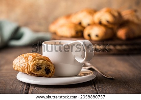 White cup of tea with mini chocolate bun, puff pastry on old wooden table. Tasty tea break concept, copy space. Royalty-Free Stock Photo #2058880757