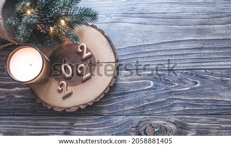 Christmas flat lay on a wooden table, golden numbers 2022 and new year decor, copyspace