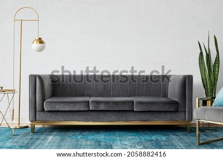 Chic mid-century modern luxury aesthetics living room with gray velvet couch and blue rug Royalty-Free Stock Photo #2058882416