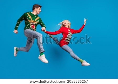 Full body profile photo of funky young couple jump wear sweater jeans socks shoes isolated on blue background