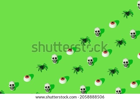 Creative idea made of skull, eye and spider on green background. Minimal Halloween boo concept. Copy space.