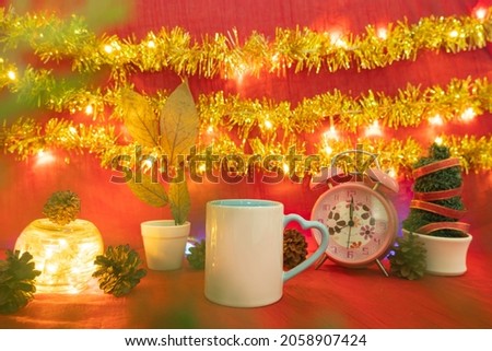 Minimalist concept idea displaying products. coffee mug on christmas and new year background.red, lights, pine flowers
