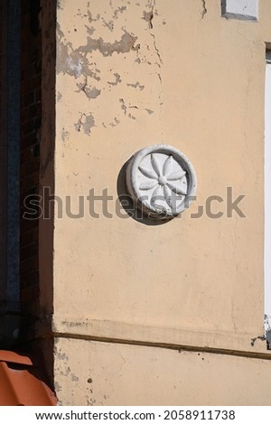 round flower-shaped decor detail on the wall of a historic building