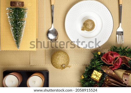 Top view of a Christmas table settings with gold color baubles. 