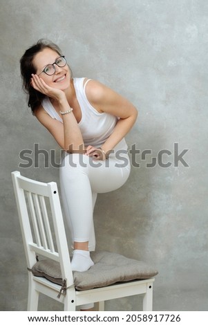 a very joyful woman in a white t-shirt on an old background