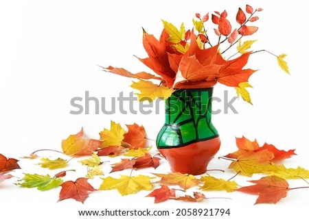 beautiful bouquet of yellow and orange maple leaves in ceramic vase on white background. Bright colors of autumn