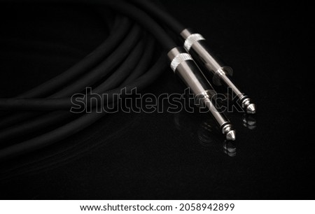 Two silver TRS connectors for the analog audio signal are placed against a black background. Professional jack connectors for sound equipment. Audiophile technologies concept.