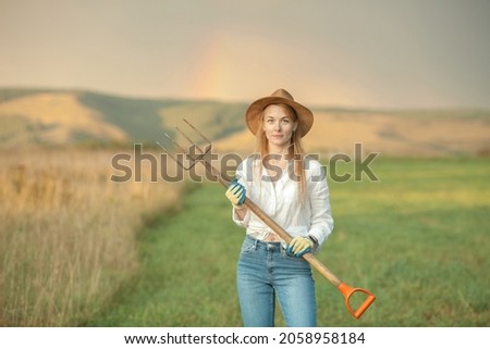 Country woman in field with pitchfork. Harvest festival
