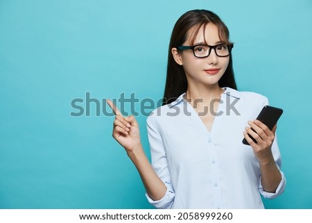 Business portrait of young Asian woman on blue background Royalty-Free Stock Photo #2058999260