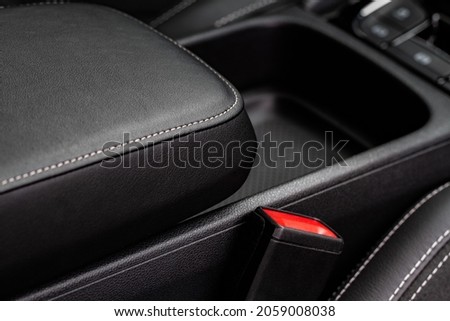 Car armrest opened. Opened armrest in the car for driver. Royalty-Free Stock Photo #2059008038